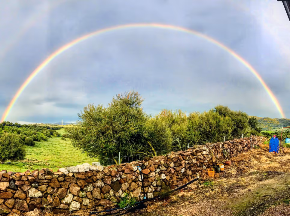 Ein Regenbogen über der Landschaft und den Trockenmauern